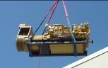 Diesel engine standby emergency generator being crane lifted into a San Francisco area telecommunication facility.